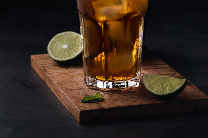 Glass of amber-colored drink with a slice of lime