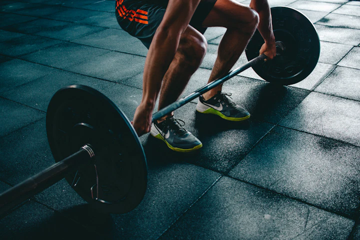 Man performing a barbell deadlift in a gym
