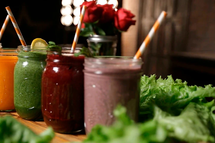 A row of colorful fruit and vegetable smoothies and juices in glass bottles