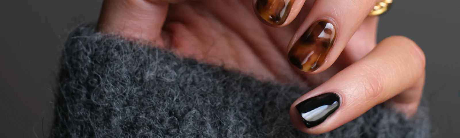 Hands with nails painted in a dark glossy polish
