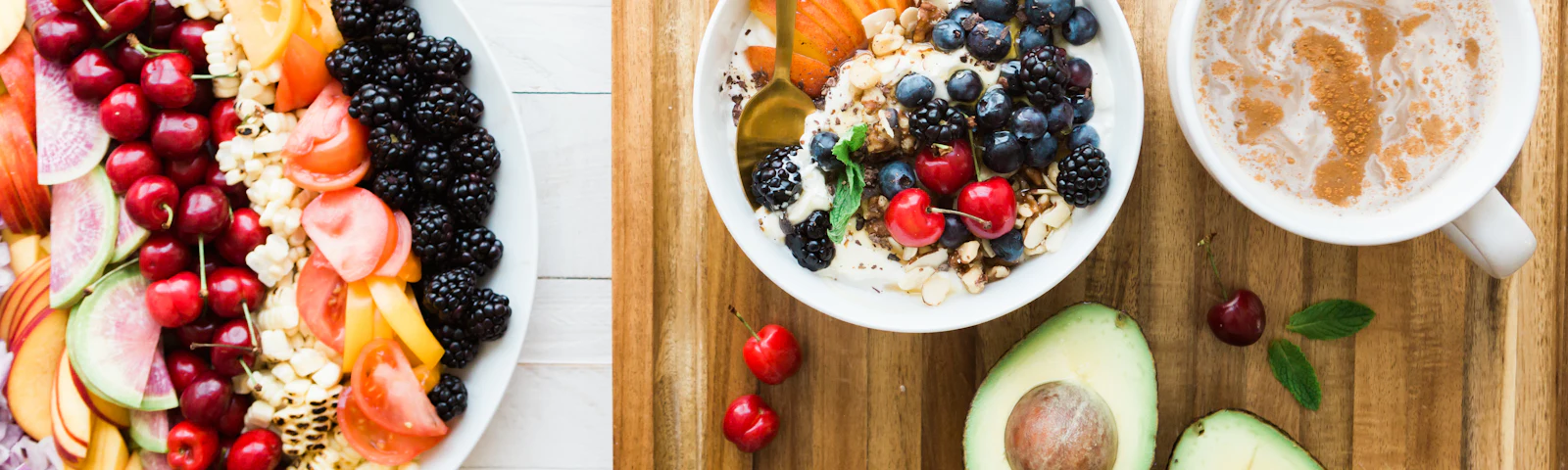Breakfast spread with fresh fruit, a bowl of oatmeal and sliced avocado on a table