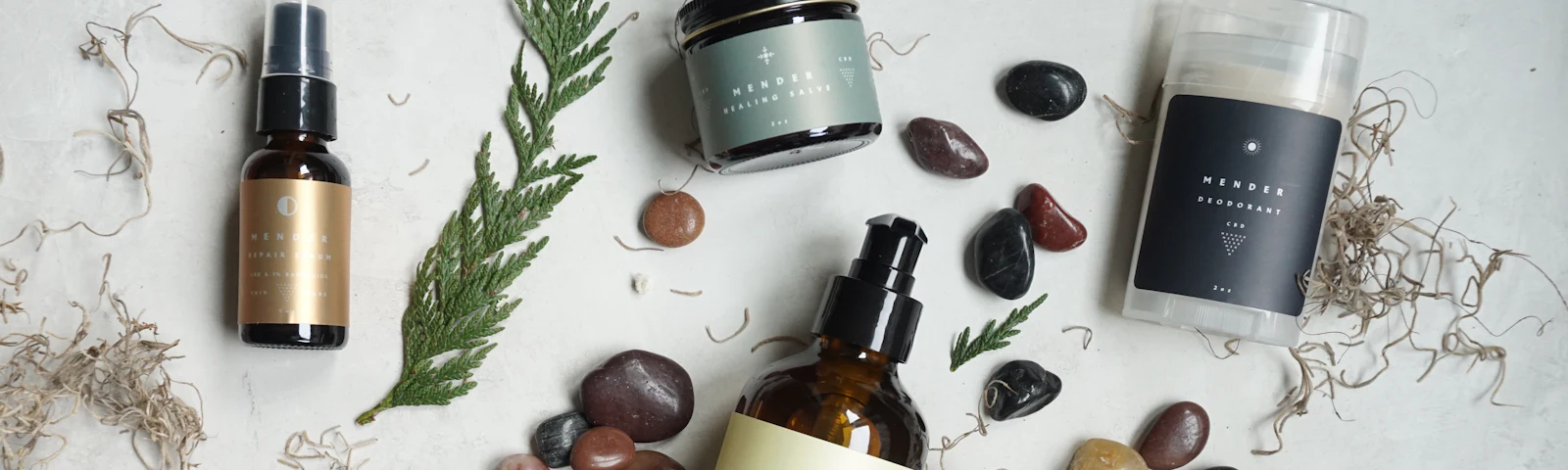 Natural skincare bottles and jars arranged with smooth stones