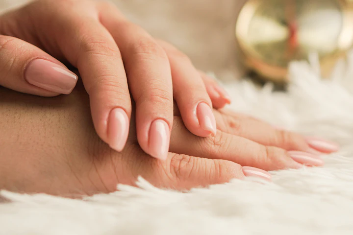 Close-up of hands with neatly manicured glossy pink nails