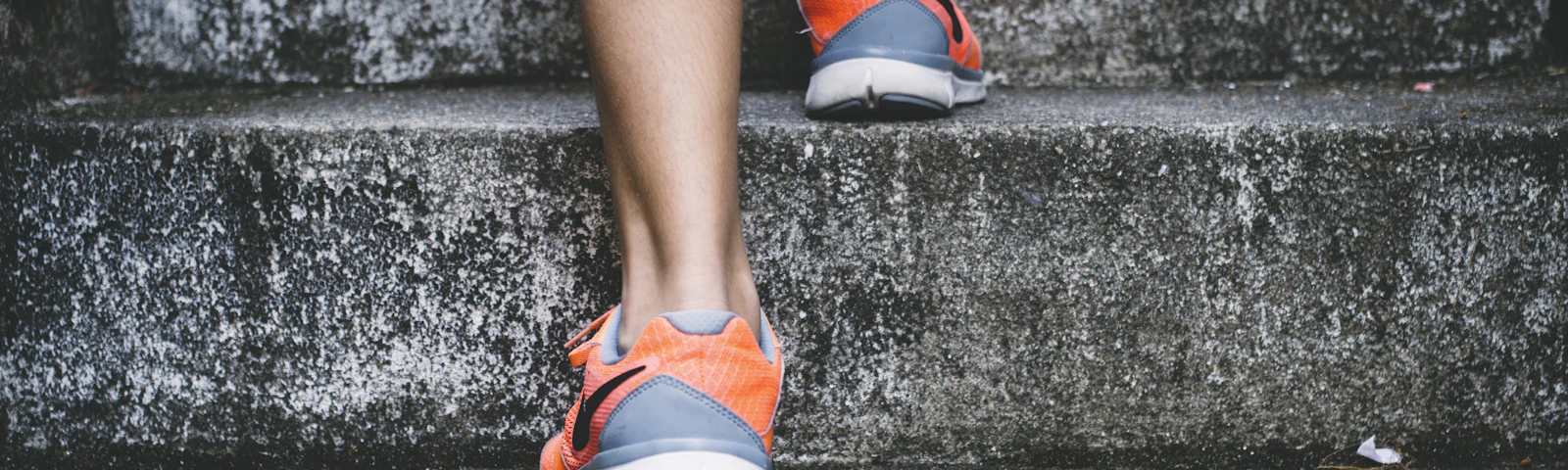 Close-up of a runner's legs and shoes on outdoor stairs