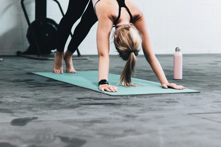 Woman stretching on an exercise mat in a gym