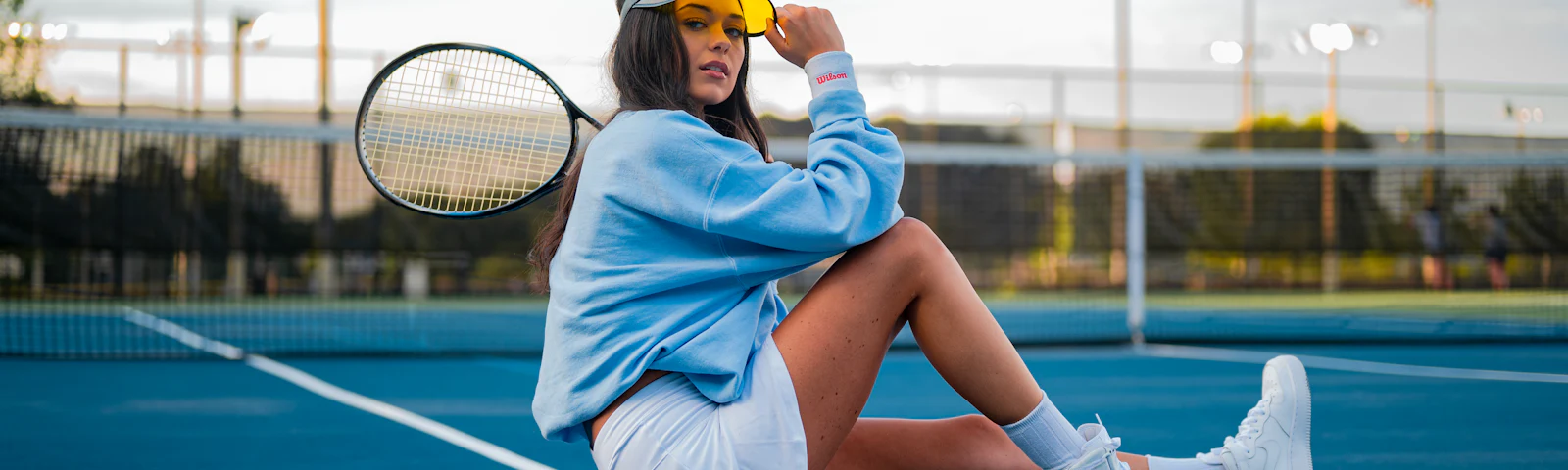 Pair of white tennis shoes resting on a hard court