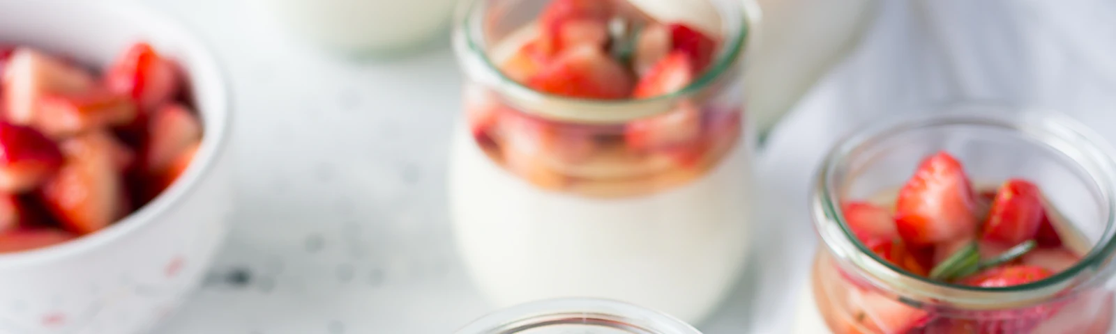 Cups of yogurt topped with fresh strawberries